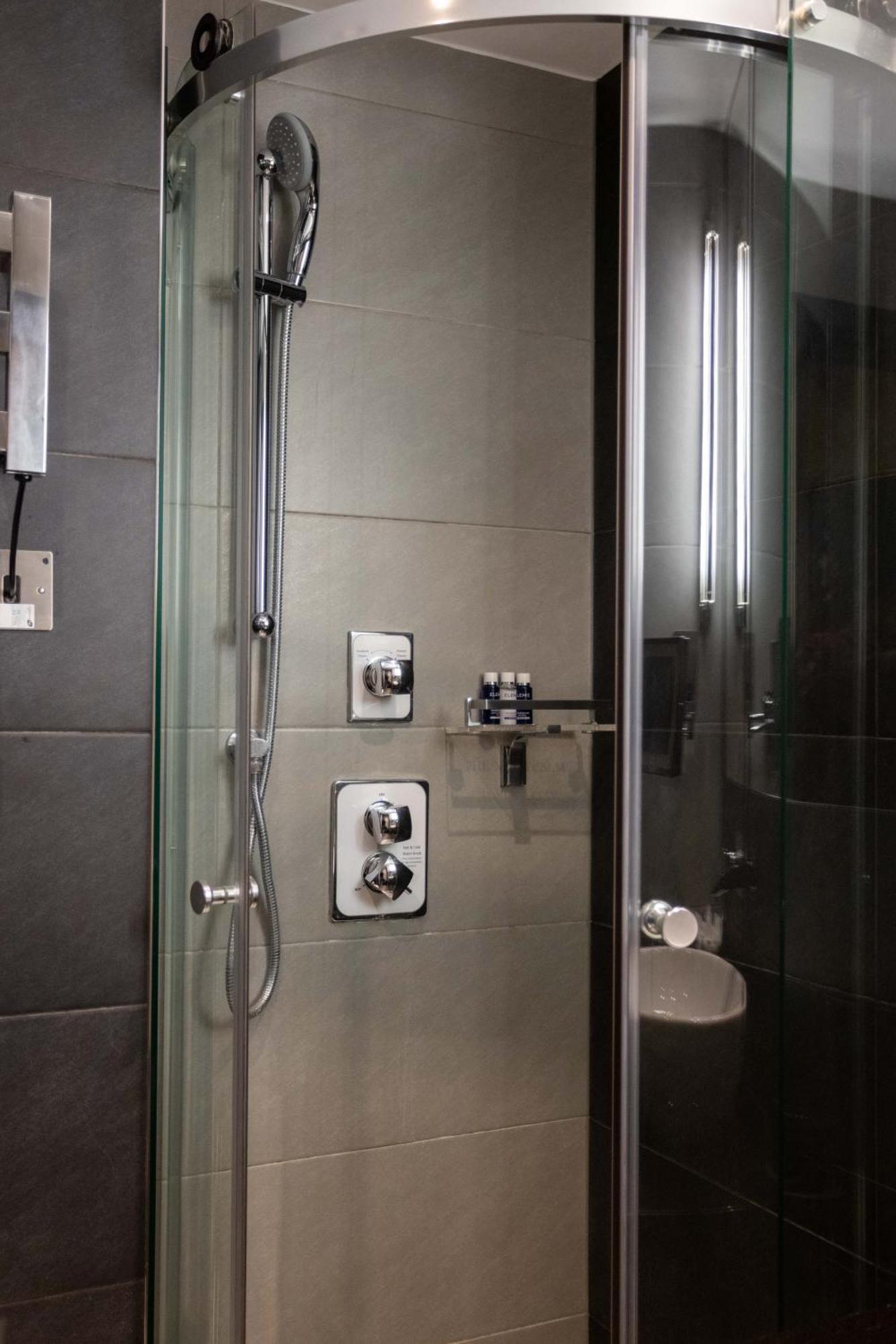 Montcalm Brewery Townhouse Hotel Londres Exterior foto The photo shows a modern shower area. It features glass panels and tiled walls in a neutral color palette, creating a sleek and contemporary look. There are two main control panels for adjusting the water temperature and pressure, with various knobs 