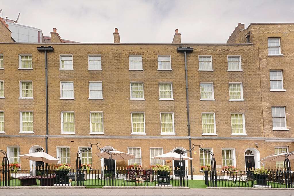 Montcalm Brewery Townhouse Hotel Londres Exterior foto The photo shows a brick building with several windows on its facade. The structure appears to be three stories tall, featuring a symmetrical design with multiple windows that have white frames. In front of the building, there is a landscaped area wit