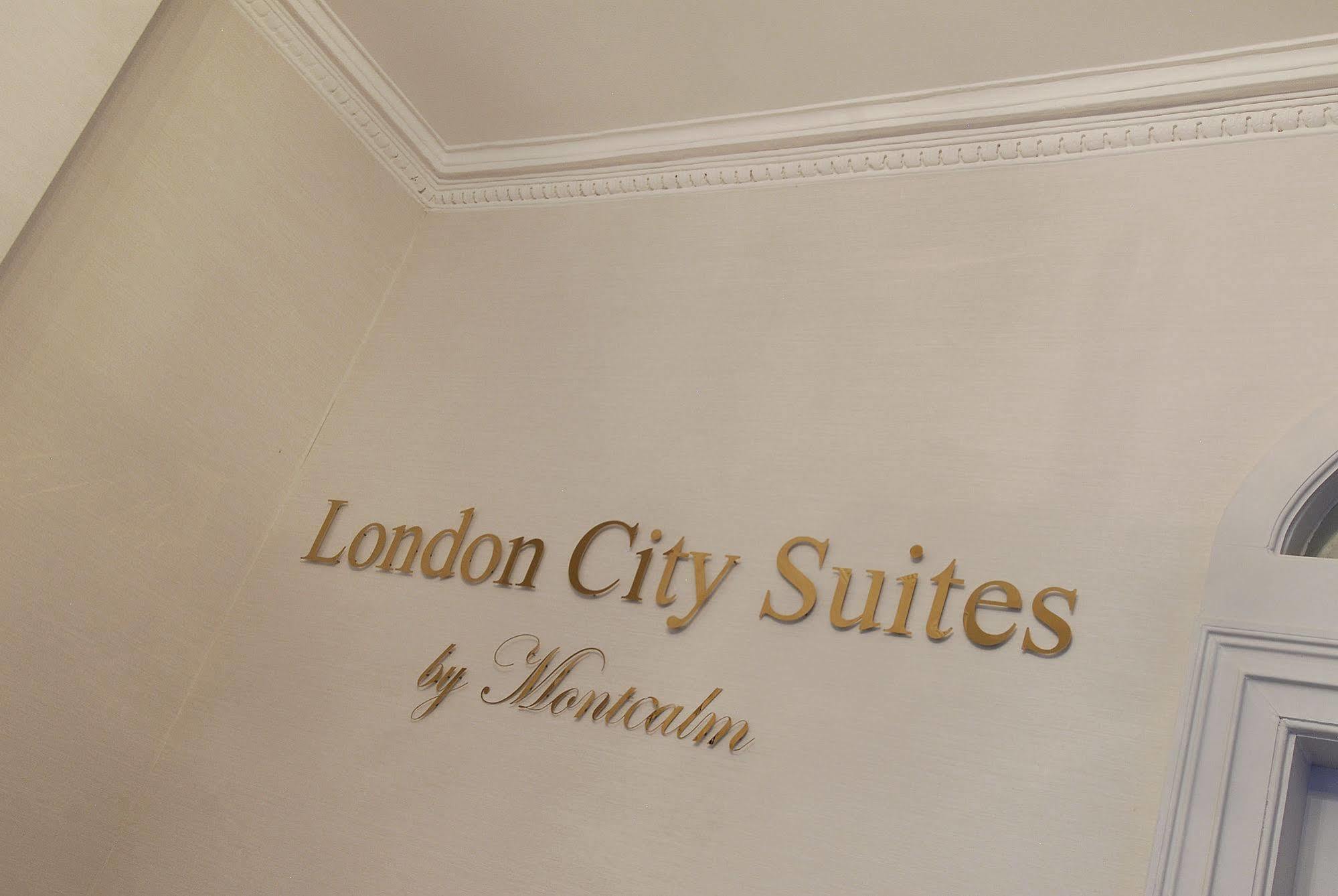 Montcalm Brewery Townhouse Hotel Londres Exterior foto The photo shows a wall display featuring the text "London City Suites" in a bold, gold-colored font. Below that, the words "by Montcalm" are written in a smaller, elegant style. The background appears to be a neutral-colored wall, possibly in a hotel