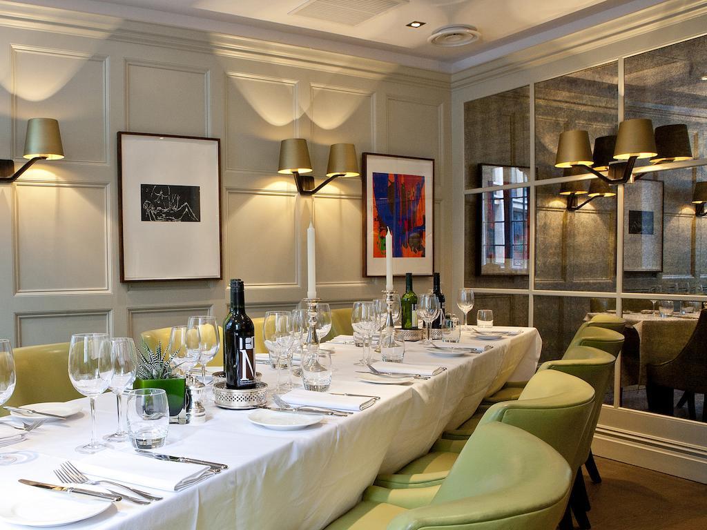 Montcalm Brewery Townhouse Hotel Londres Exterior foto The photo shows an elegant restaurant setting with a long dining table that is neatly set for a meal. The table is adorned with a white tablecloth, glassware, and silverware, indicating that it is prepared for a special gathering or event. 

Behind t