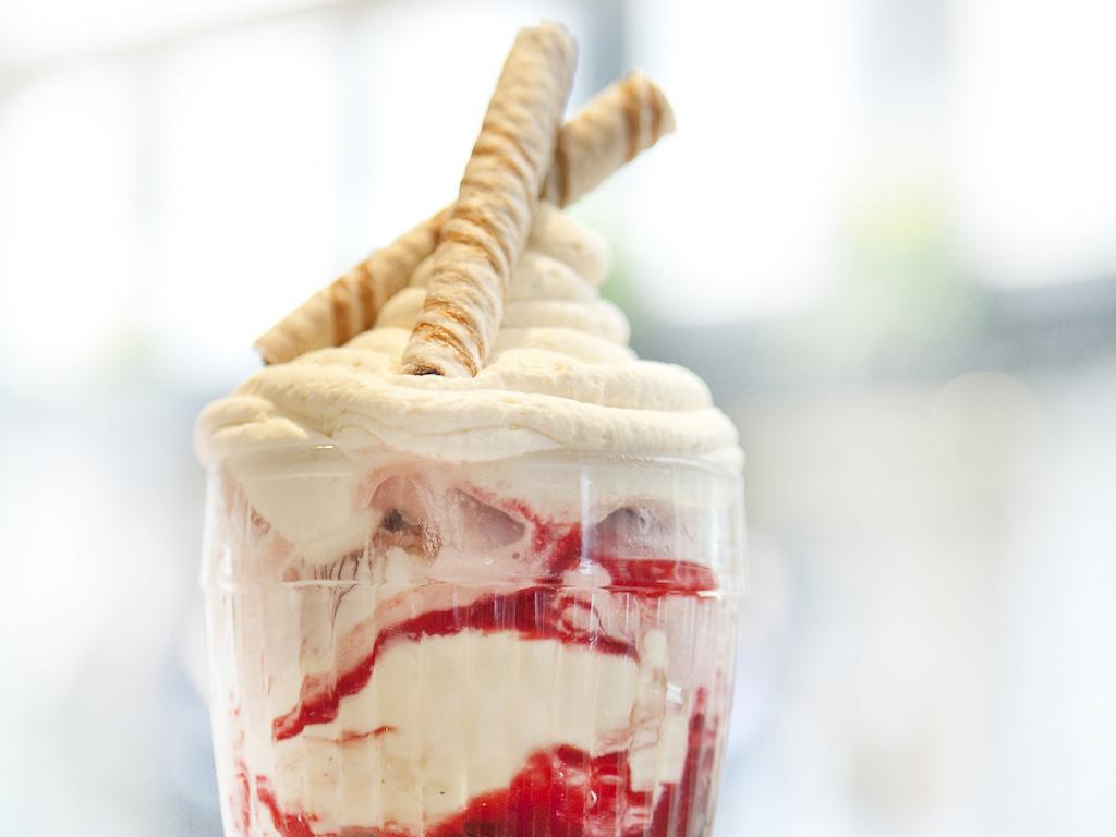 Montcalm Brewery Townhouse Hotel Londres Exterior foto The photo shows a delicious dessert in a clear glass dish. It features layers of creamy ice cream or whipped cream, swirled with a vibrant red fruit sauce. Topping the dessert are two rolled wafer sticks, adding a decorative touch. The overall presen