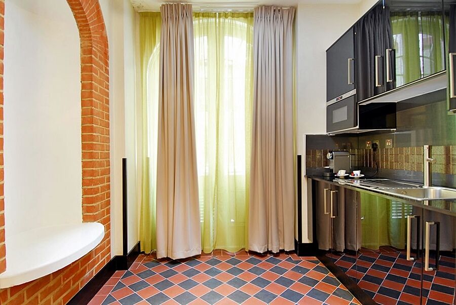 Montcalm Brewery Townhouse Hotel Londres Exterior foto The photo shows a kitchen area with modern design elements. There are large, light-colored curtains hanging from the windows, allowing natural light to filter in. The walls are partially exposed brick, giving a warm texture to the room. The flooring 